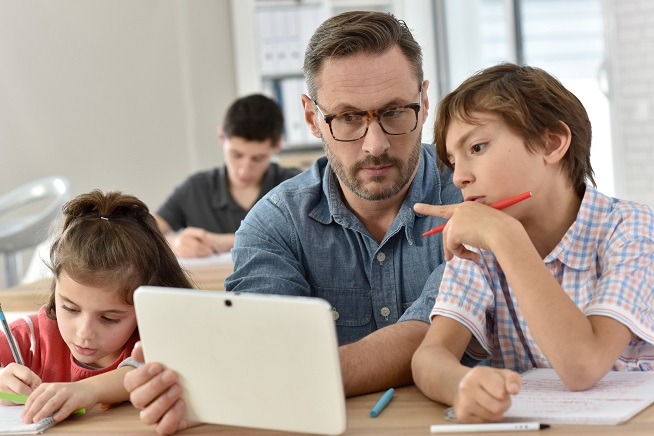 teacher with students in class using digital tablet